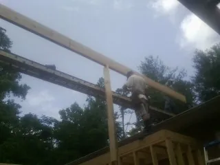 Carpenter setting a ridge beam over a new addition frame — Ice Dam Removal by Roofing Brothers in Shepherd